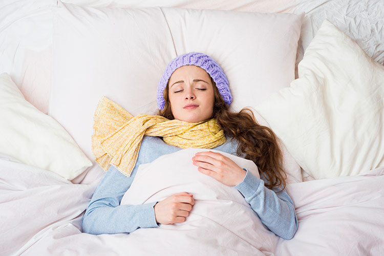 Woman-sleeping-in-warm-bed-with-layers-on-in-cold-temperature.jpg